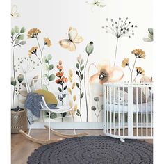 a baby's room with flowers and butterflies painted on the wall, along with a crib