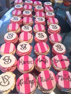 cupcakes with pink and white frosting are on display