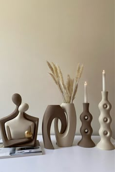 there are three vases and two candles on the table