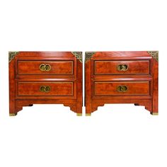 a pair of wooden nightstands with brass handles