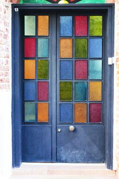 a multicolored glass door on the side of a building