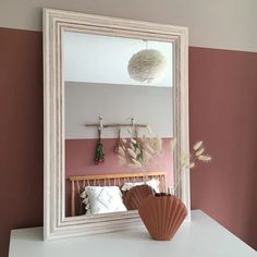 a mirror sitting on top of a white dresser