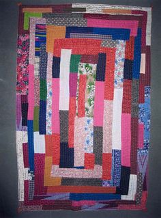 a multicolored patchwork quilt hanging on a wall