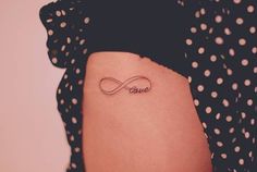 a woman's thigh with a tattoo on it that says love and an infinite knot