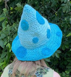 a woman wearing a blue crocheted hat with polka dots