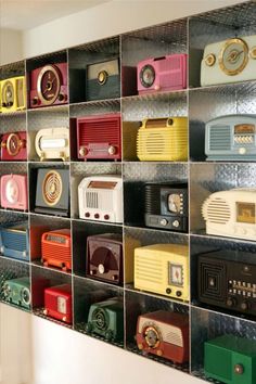 there are many radio's on the shelves in this room, all different colors