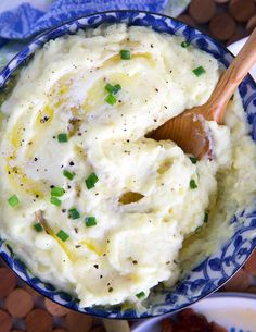 mashed potatoes in a blue bowl with a wooden spoon