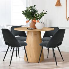 a table with four chairs around it and a potted plant in the middle on top