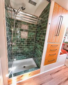 a bathroom with green and orange tiles on the shower wall, toilet and bathtub