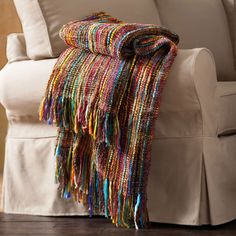 a multicolored blanket sitting on top of a white couch