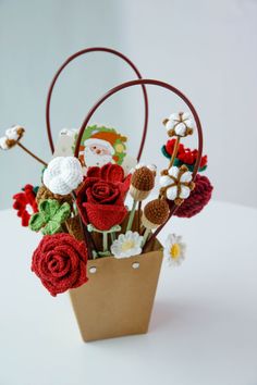 a vase filled with lots of flowers on top of a white table next to a brown bag