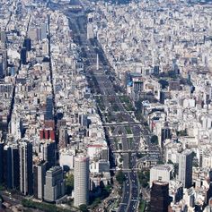 an aerial view of a large city with lots of tall buildings and roads in the foreground