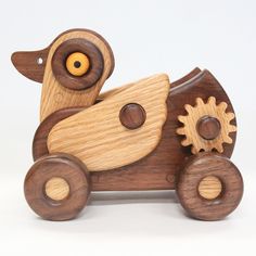 a wooden toy car with gears in the shape of a dog on it's back