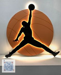 the silhouette of a basketball player is on display in front of a wall with an orange ball