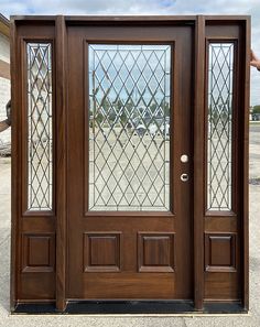 the front door is made of wood and has two glass panels on each one side