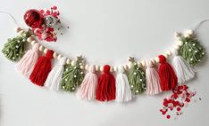 a string of tassels and beads are hanging on a white wall next to other decorations