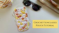 a crochet sunglasses case sitting on top of a table next to some yarn