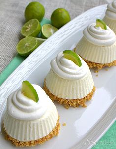 three small desserts on a white plate with limes in the backgroud