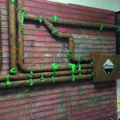 a brick wall with pipes and green paint on it