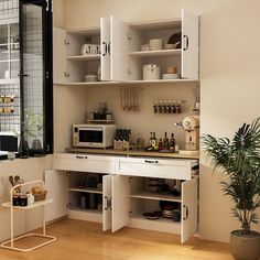 a kitchen with white cupboards and shelves filled with food, drinks and utensils