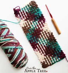 an apple tree knitting project with yarn and crochet needles on the table next to it