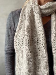 a woman wearing a white knitted scarf