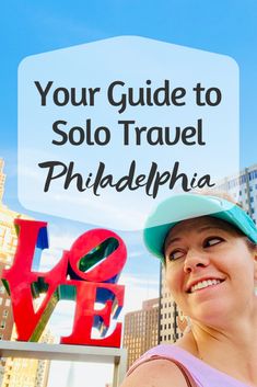 a woman standing in front of a love sign with the words your guide to solo travel philadelphia