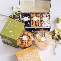 a box filled with lots of different types of donuts next to boxes of treats