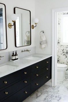 a bathroom with two sinks, mirrors and a toilet in the corner next to each other