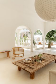 a table with plates and bowls on it in a room that has arches leading to the outside