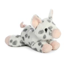 a white and gray stuffed animal laying on its side with black dots around it's eyes