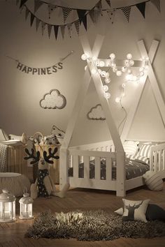 a bedroom with a canopy bed and string lights on the ceiling, along with other decorations