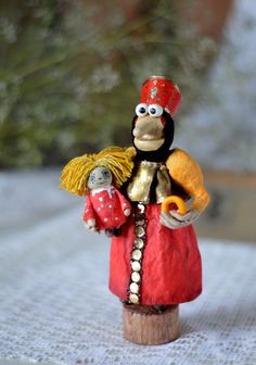 a small figurine is dressed in red and gold