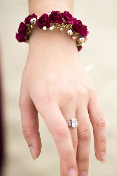 a close up of a person wearing a bracelet with flowers on it's wrist