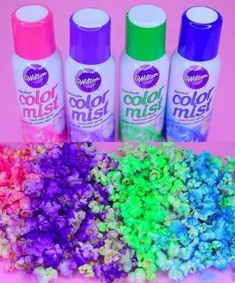 four spray bottles filled with different colored confetti