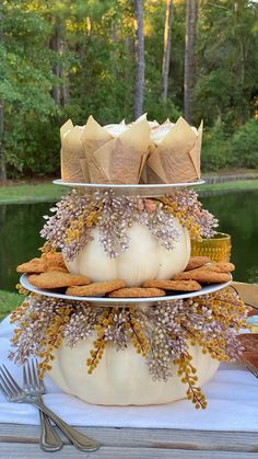 DIY fall tiered tray made with two faux pumpkins and two plates stacked on top of one another. In between the tiers are faux fall stems. There are cupcakes and cookies displayed on it. Fall Treat Table Ideas, Cake Plate Decor Display Fall, Fall Cookie Table Display, Creative Ways To Display Cupcakes, Diy Fall Topiary Tree, Fall Dollar Store Diy, Fall Appetizer Table Display, Halloween Decorative Tray, Diy Food Table Display