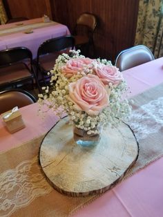 pink roses and baby's breath in a vase on a table at a restaurant