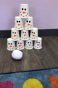 a pile of snowmen sitting on top of a wooden floor next to a white ball