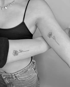 a woman with a rose tattoo on her left arm and right arm behind her back