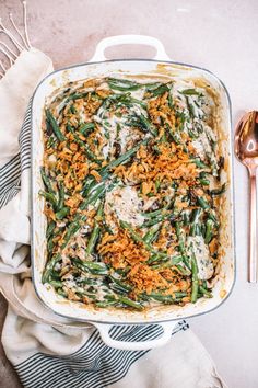 a casserole dish filled with green beans, cheese and bread crumbs