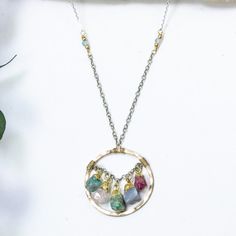 The zinnia necklace adds a rainbow of colors to your look like the zinnia flower adds a rainbow to your garden. Brightly colored rough gemstones dance within a hand forged, gold pendant and are accented with textured chains and tiny beads. •14k gold filled and sterling silver •Apatite, rose quartz, turquoise, chalcedony, and ruby, with blue topaz accent •Pendant is about 1" •Length: 17" Bohemian Birthstone Pendant Jewelry, Bohemian Pendant Necklaces With Birthstone, Artisan Birthstone Pendant Necklace, Multicolor Natural Stones Round Pendant Necklace, Artisan Necklace With Gemstone Flower Pendant, Artisan Multi-stone Round Bead Necklaces, Turquoise Multi-stone Round Necklace, Artisan Multi-stone Pendant Jewelry, Zinnia Flower