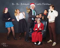 a group of people standing around each other in front of a christmas card board with the caption ho ho herman family christmas