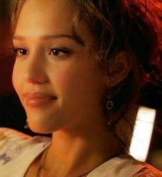 a close up of a woman with red hair and earrings on her head looking off to the side