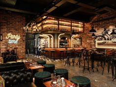 the interior of a bar with lots of tables and stools in front of it