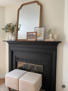 a living room with a fireplace, mirror and ottoman