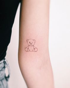 a small teddy bear tattoo on the arm