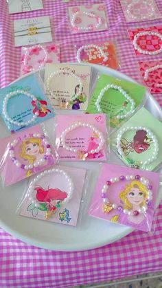 there are many cards on the table with little princesses and pearls around them, all in different colors