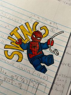 a spiderman sticker on top of a notebook with some writing in the background