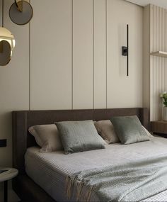 a large bed sitting in the middle of a bedroom next to a wall mounted clock