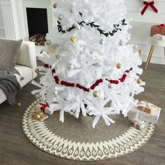 a white christmas tree with red and gold ornaments